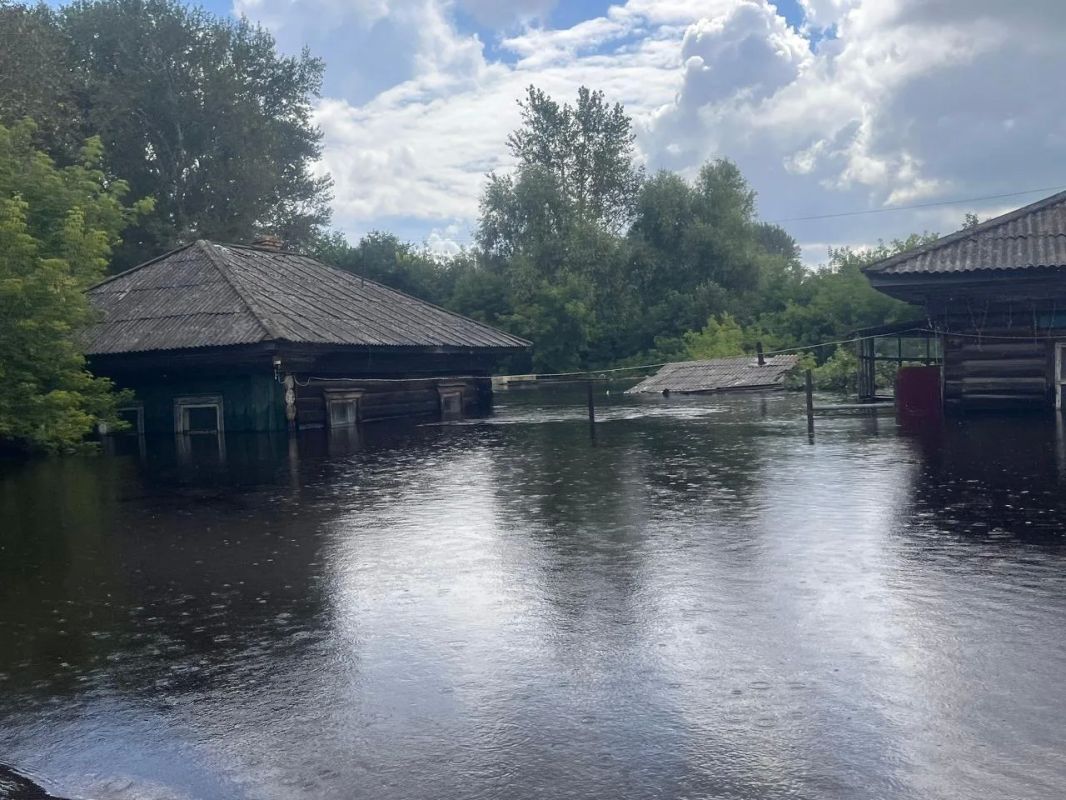 Некоторые дома стоят почти по крышу в воде, спасатели эвакуируют жителей на лодках Некоторые дома стоят почти по крышу в воде, спасатели эвакуируют жителей на лодках